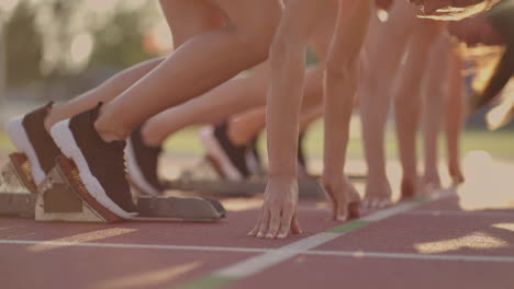 Three-female-athletes-simultaneously-start-running-marathon-rivalry-slow-motion.-women-standing-on-a-starting-line-before-race